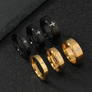 Macro detail of gold and black stainless steel rings with minimalist cross engraving