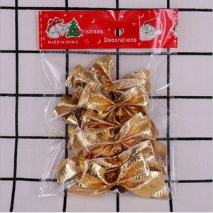 Set of shiny golden Christmas bows for tree decoration in clear packaging with red card header