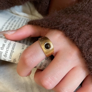 Close-up of a vintage gold oval ring with a black gemstone and radial texture