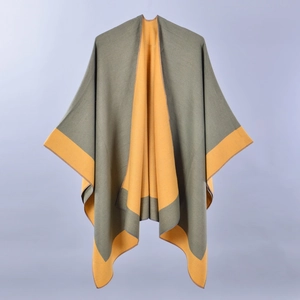 Detail of soft olive green and ginger yellow cashmere-feel knitted poncho wrap
