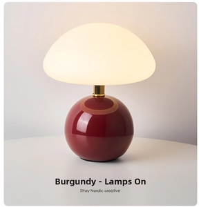Detail of mushroom lamp with wine red glossy base and soft glowing white shade