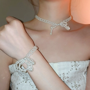 Détail de l'ensemble collier et bracelet en perles avec un design de nœud élégant