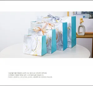 Set of four marble texture gift bags with elegant ribbon bows in various sizes