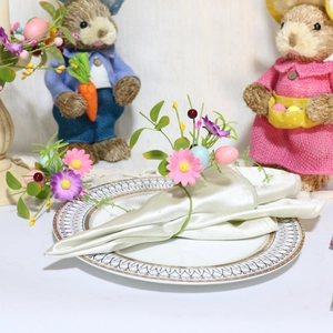 Close-up of Easter napkin ring with pink daisies, purple flowers and festive eggs