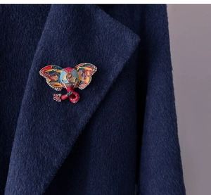 Detail of colorful enamel elephant butterfly brooch with rhinestones on navy coat
