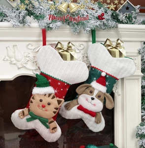 Detail of knit bone-shaped Christmas stockings with cat and dog decor on a fireplace