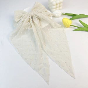Detail of cream chiffon oversized hair bow with flocking polka dots and long ribbons