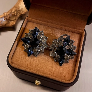 Close-up of vintage flower earrings with dark grey and black diamond inlay work