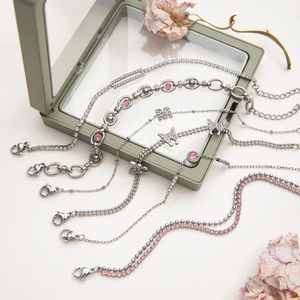 Macro shot of silver zircon butterfly bracelets on a pale green jewelry box
