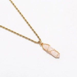 Detail of rose quartz hexagonal crystal pendant with gold wire wrap and rope chain
