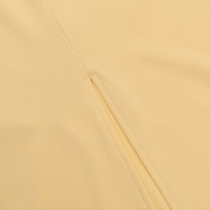 Detailed close-up showing precision stitching and split hem of the pale yellow woven dress