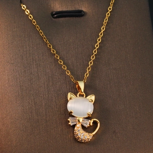 Golden cat pendant necklace with white opal and zircon stones on a leather texture background