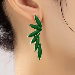 Elegant green enamel leaf earrings with gold metal edges shown on a model