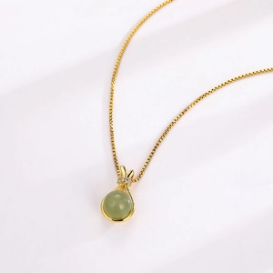 Elegant gold necklace with lucky bag pendant featuring green jade and small diamonds