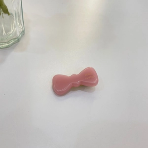 Pink jelly bow hair clip with gold France Handmade text on a minimalist white surface