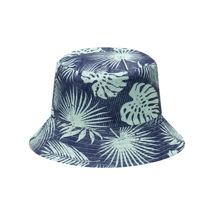 Detailed view of tropical leaf prints on navy blue cotton fabric of the sun bucket hat