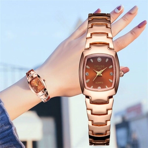 Detail of rose gold tonneau watch with brown dial and rhinestone hour markers
