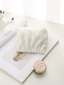 Detail of cream corduroy storage bag showing soft vertical ribbed texture and elastic closure