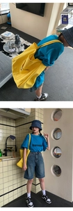 Street style view of a large yellow canvas bag worn with a casual blue harvest tee