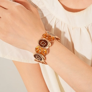 Détail d'un bracelet vintage en or avec émail ambre et motif d'étoile gravé