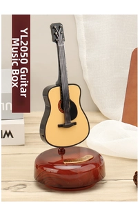 Close-up of a guitar music box on a wooden base with a golden Music Box plaque