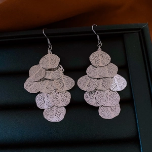 Close-up of layered hollow leaf tassels in silver finish on a jewelry display