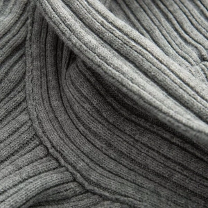 Detailed macro view of the grey ribbed knit fabric showing high-quality wool texture