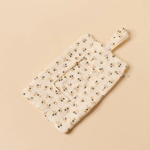 Close-up of baby crib hanging wipe bag with yellow floral pattern on soft cotton muslin fabric