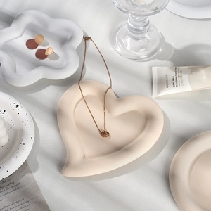 Decorative heart and star jewelry storage trays with matte ceramic finish for photography