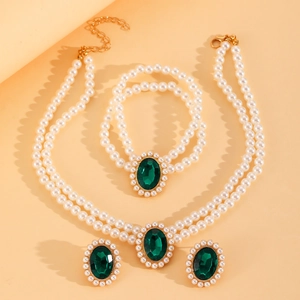 Détail de l'ensemble collier et bracelet en perles avec gemmes vertes ovales et dorures