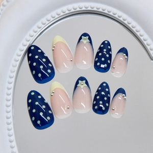 French almond press-on nails with blue polka dots, silver stars, and glossy finish