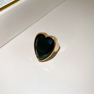 Macro shot of heart-shaped green zircon gemstone with gold-plated bezel setting