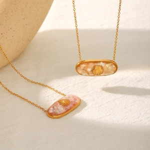Gold oval shell pendants with pink resin inlay and seashell charm on steel chain
