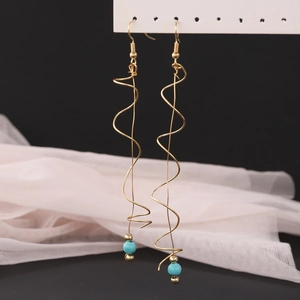 Detailed view of bohemian gold spiral tassel earrings with sky blue turquoise beads