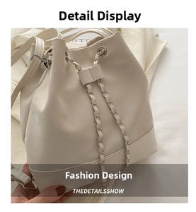 Detail view of cream bucket bag showing drawstring silver chain and fine leather texture