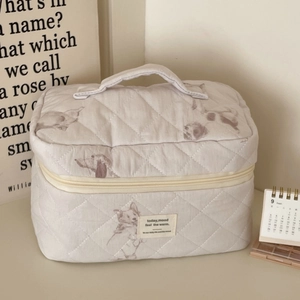 Detail of quilted cotton makeup bag with purple puppy print and soft top handle
