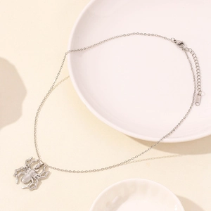 Detailed close-up of silver stainless steel spider pendant on an O-shaped chain