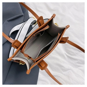 Interior view of canvas tote bag showing grey lining, pockets, and two shoulder straps