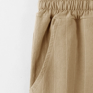 Dettaglio dei pantaloni in lino kaki con vita elastica e tasca laterale pratica