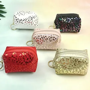 Top view of five leopard print mini coin purses with gold hardware and zipper details