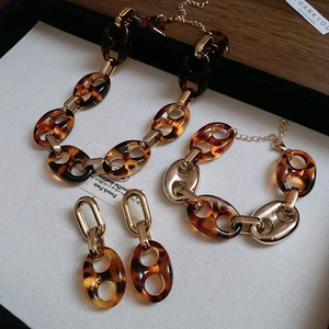Dettaglio set di gioielli in resina leopardata e catena dorata con collana e orecchini