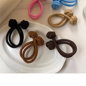 Macro shot of colorful high elasticity hair ties with double knot design on a white tray