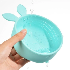 Close-up of baby silicone bath brush with rabbit ears being washed under running water