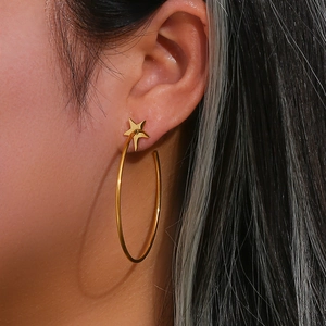 Fashionable large gold stainless steel hoop earrings with pentagram star charm on model
