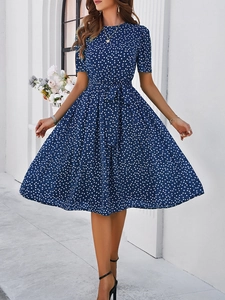 Détail d'une robe midi bleue à pois avec manches courtes et ceinture nouée à la taille
