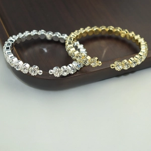 Gold and silver open bangles with rows of sparkling crystals on a wooden display