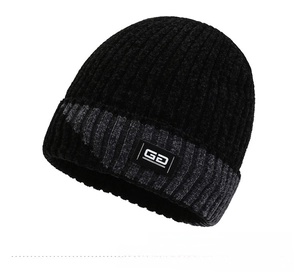 Close-up of black and grey knit beanie featuring a white GD rectangular patch label