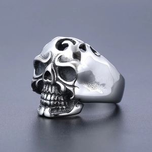 Detailed close-up of retro hollow skull ring in polished stainless steel with dark accents