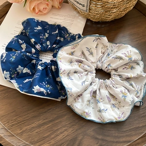 Detail of floral fabric scrunchies with bunny patterns on a rustic wooden background