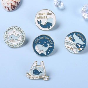 Blue whale enamel pins set with ocean conservation quotes on light blue background